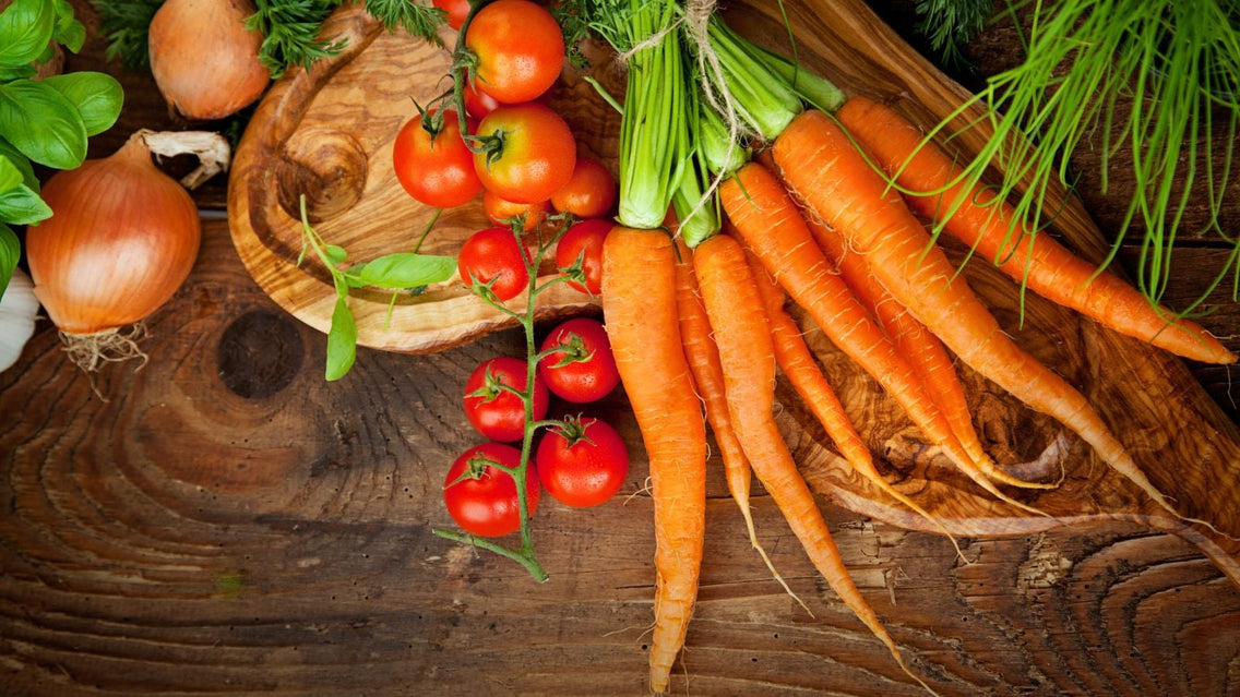 An overhead flatlay shot of several crops that showcases carrot companion plants