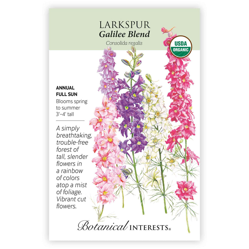 Seed packet for Galilee Blend Larkspur showing illustrated tall flower spikes in pink, purple, cream, and magenta with feathery green foliage, plus text noting it's an organic annual for full sun, blooming spring to summer, growing 3 to 4 feet tall.