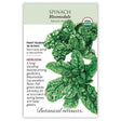 Seed packet for Bloomsdale organic heirloom spinach, illustrated with deeply crinkled, savoyed dark green leaves, and printed text noting it's frost tolerant, matures in 28–45 days, and sown in early spring or late summer.