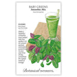 Seed packet for Baby Greens Smoothie Mix showing an illustrated glass of green smoothie with a striped straw beside a pile of mixed green and reddish-purple baby leaves on a wooden board, with text noting a 25-35 day growth period and sowing indoors year-round.