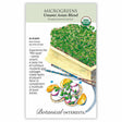 Seed packet for USDA Organic Umami Asian Blend Microgreens, illustrated with a wooden tray of dense green mustard and cabbage sprouts, chopsticks, and a plated dish of radish slices with microgreens and orange wedges, with text noting a 10–15 day indoor sowing time and describing the savory umami flavor blend.