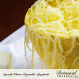 Close-up view of cooked, shredded spaghetti squash strands served inside the squash skin, labeled "Squash Winter Vegetable Spaghetti" for Botanical Interests.