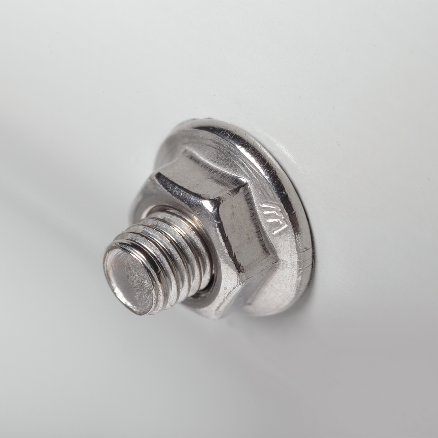 Close-up of a stainless steel hex-flange bolt threaded into a pre-drilled hole on the raised garden bed's metal panel, showing the fastener's textured washer head and visible threads.