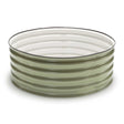 Round corrugated metal raised garden bed in sage green, low and wide with visible seam rivets, shown empty against a plain white background.
